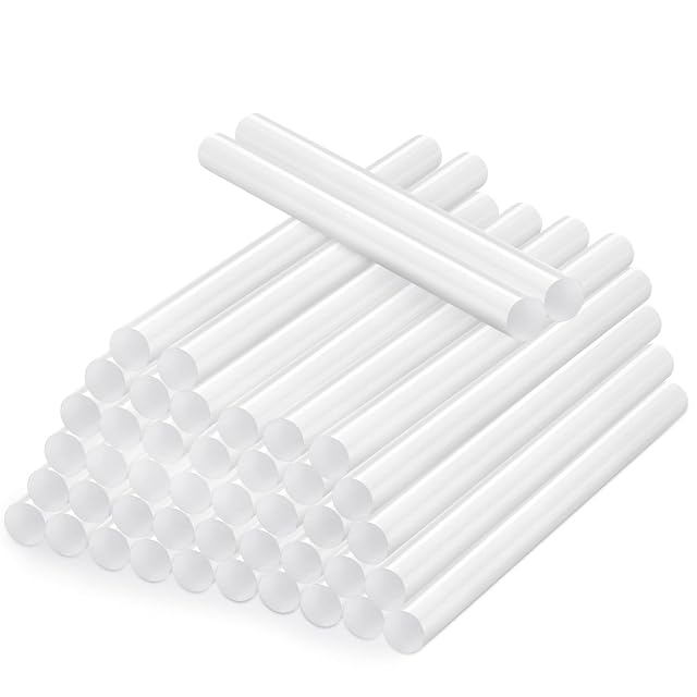 Stack of white glue sticks with two lying across the top