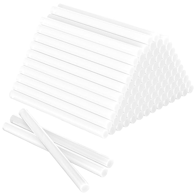 Pyramid of white glue sticks with three loose sticks in front