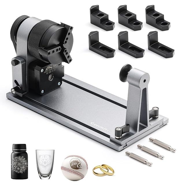 Genmitsu chuck on a long base with a tailstock, six spare jaws, three pins, and an engraved bottle, glass, ball and rings
