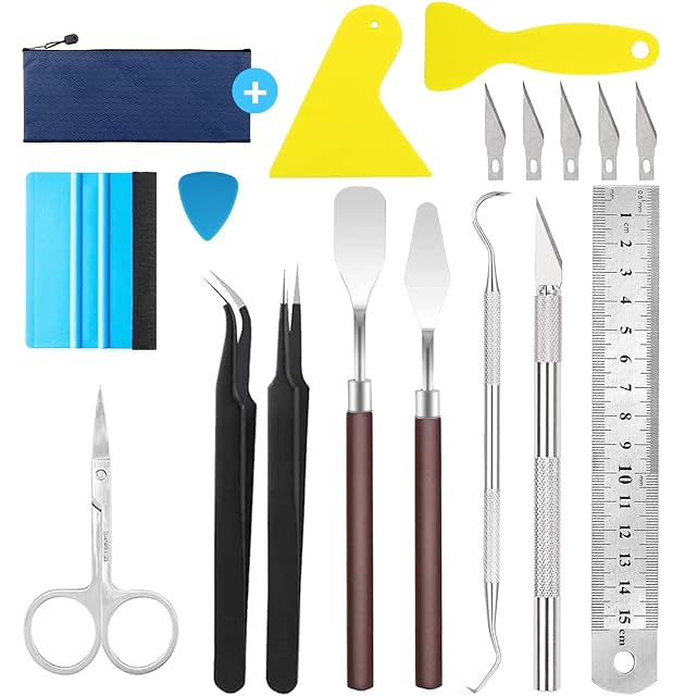 Tools laid out: zip pouch, two yellow scrapers, a felt-edged squeegee, a pick, five blades, tweezers, two spatulas, hook, craft knife, steel ruler and scissors